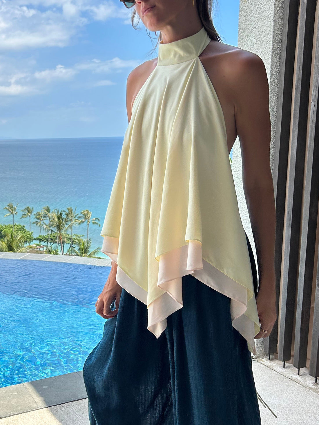 Woman wearing reversible Butter halter scarf top with open back